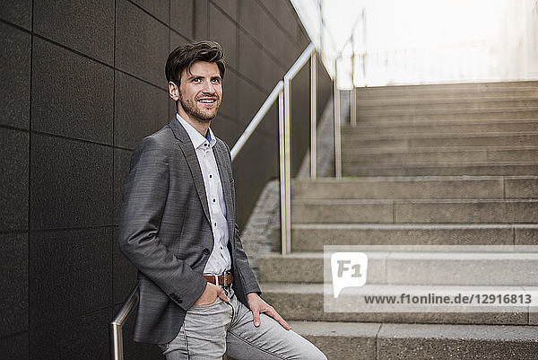 Smiling businessman standing on stairs