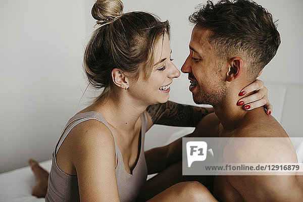 Happy young couple in bed smiling at each other
