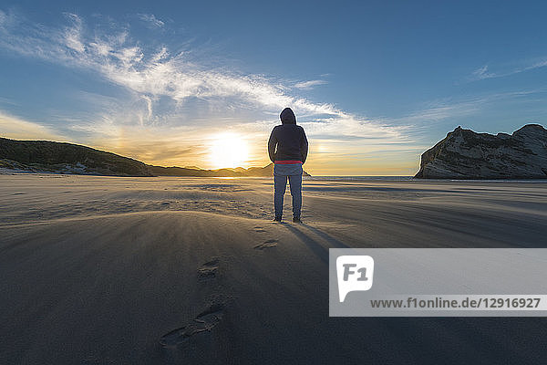 New Zealand  South Island  Puponga  Wharariki Beach  Woman on the beach at sunset