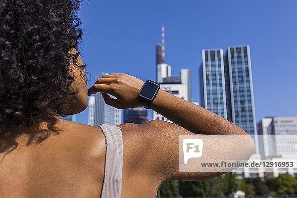 Germany  Frankfurt  back view of young woman wearing smartwatch