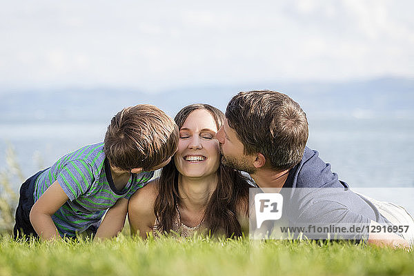 Germany  Friedrichshafen  Lake Constance  father and son kissing happy mother
