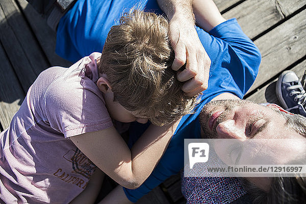 Family and son lying on a jetty