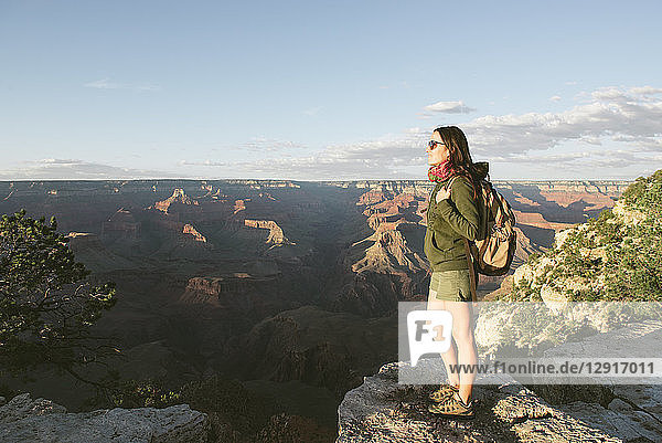 USA  Arizona  Grand Canyon National Park  Young woman with backpack exploring and enjoying the landscape at sunset