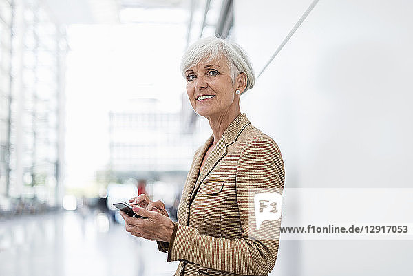 Portrait of smiling senior businesswoman using cell phone