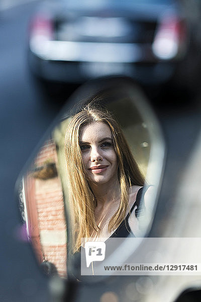 Portrait of a woman reflecting in a rear mirror