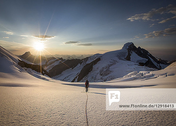 Rückansicht eines Wanderers in den winterlichen Bergen bei Sonnenuntergang  Mount Robson  British Columbia  Kanada