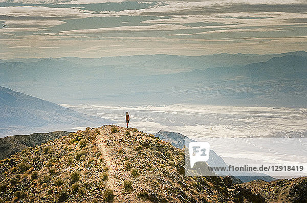 A man stands on a peak looking out over Death Valley at Dantes View  California  USA