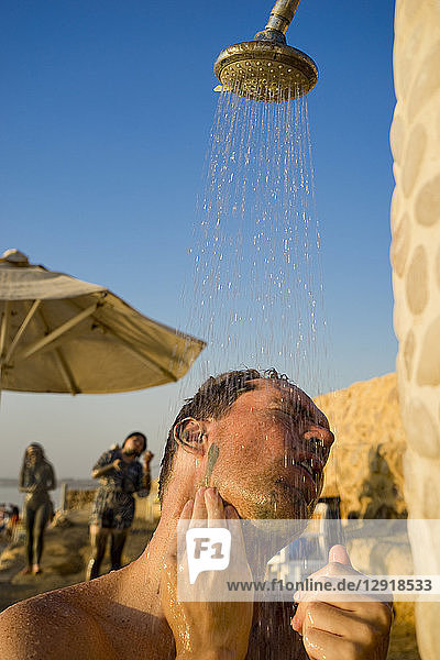 Kopf- und Schulteraufnahme eines Mannes beim Duschen im Freien  Totes Meer  Madaba Governorate  Jordanien