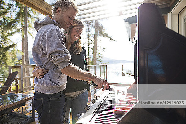 Junges Paar beim Grillen in einer Hütte am See  Kamloops  British Columbia  Kanada