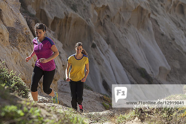 Zwei Frauen laufen in einem Sandsteingebiet in der Nähe des Torrey Pines State Park in La Jolla  San Diego  Kalifornien  USA