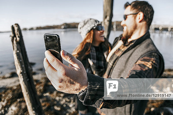 Paar  das ein Selfie macht  während es am Wasser abhängt  Peaks Island  Maine  USA