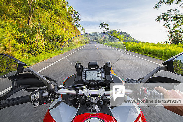 Personal perspective of biker riding on empty countryside highway ¬ÝChiang¬ÝRai ¬ÝMueang¬ÝChiang Rai District  Thailand