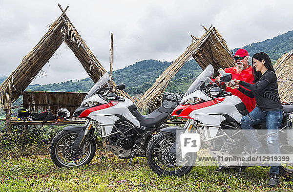 Mann und Frau schauen sich auf einer Motorradtour die Landkarte an  Nan  Bezirk Mueang Chiang Rai  Thailand