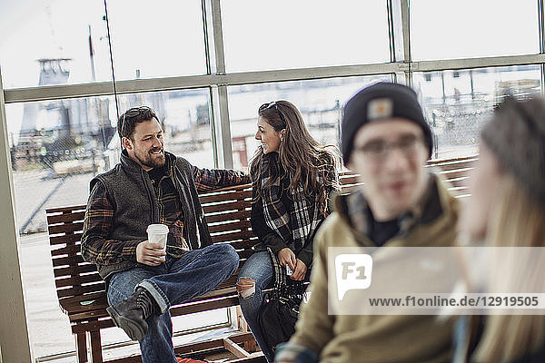 Vier erwachsene Freunde sitzen und unterhalten sich beim Warten am Fährterminal  Portland  Maine  USA