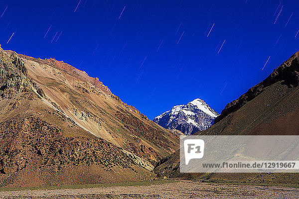 Sternenschweif über den Hügeln mit dem Aconcagua-Gipfel im Hintergrund  Argentinien