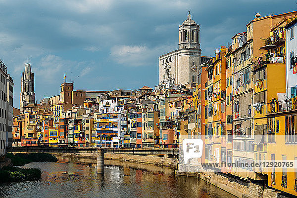 Colourful houses on the embankment of the River Onyar in historic centre with Girona's Cathedral in the background on right Girona Catalonia Spain Europe