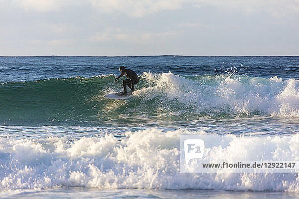 Surfer rides waves  Unstad  Vestvagoy  Lofoten Islands  Nordland  Norway