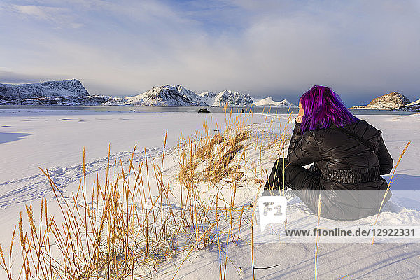 Frau am verschneiten Strand von Haukland  Leknes  Vestvagoy  Lofoten  Nordland  Norwegen