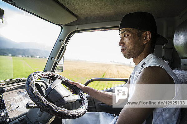 Portrait of Japanese farmer sitting in his tractor.