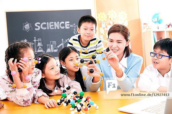 Female teachers and students use computers in the classroom