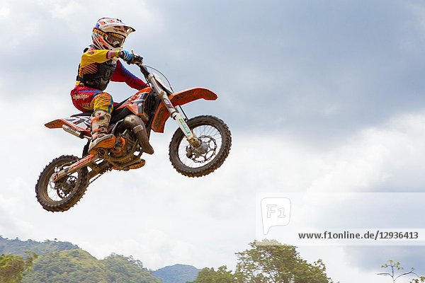 Motocross kid driver jumping in a race. Colombia. South America.