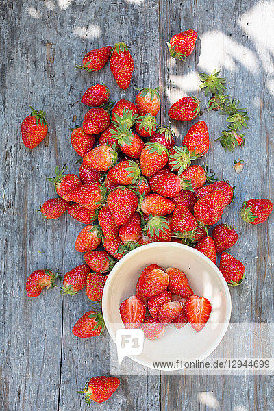 Frische Erdbeeren auf blauem Holztisch im Freien