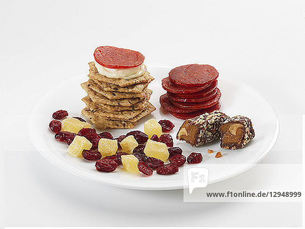 Süße und herzhafte Snacks auf Tellern: Cracker  Würstchen  Trockenfrüchte und Süßigkeiten