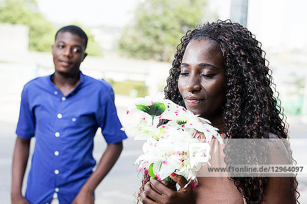 Diese junge Frau mit geschlossenen Augen nimmt ihren Blumenstrauß mit Freude und Liebe entgegen.