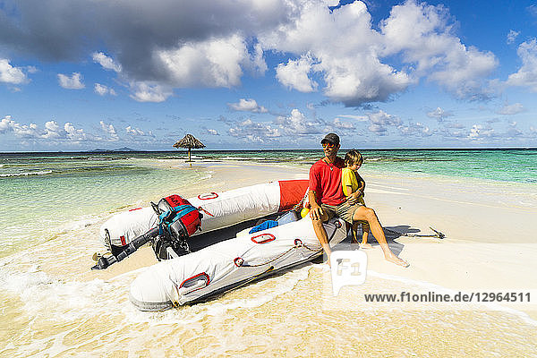 A father and his son  are sitting on a dinghy on the Morpion's island beach  St-Vincent  Saint Vincent and the Grenadines  Lesser Antilles  West Indies  Windward Islands  Caribbean  Central America