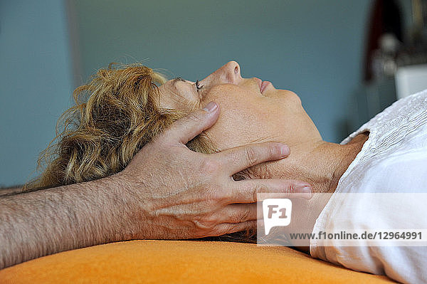 Frankreich  Person in der Praxis eines Osteopathen  Frau in chiropraktischer Behandlung  Gesichtsmassage.