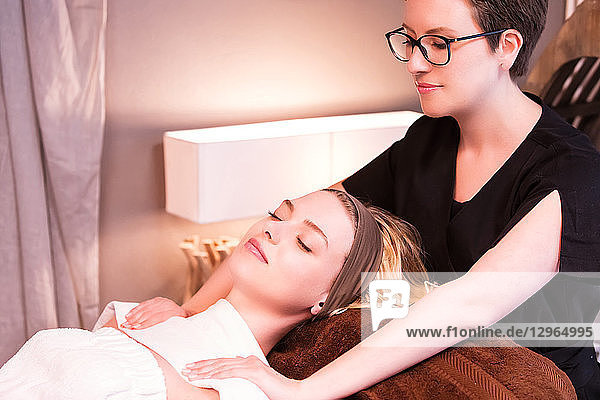 Masseuse massaging the shoulders of a young woman