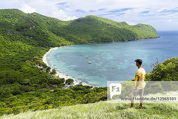 A man is looking at Chatham Bay on a point of view  a natural park  Union  St-Vincent  Saint Vincent and the Grenadines  Lesser Antilles  West Indies  Windward Islands  Caribbean  Central America