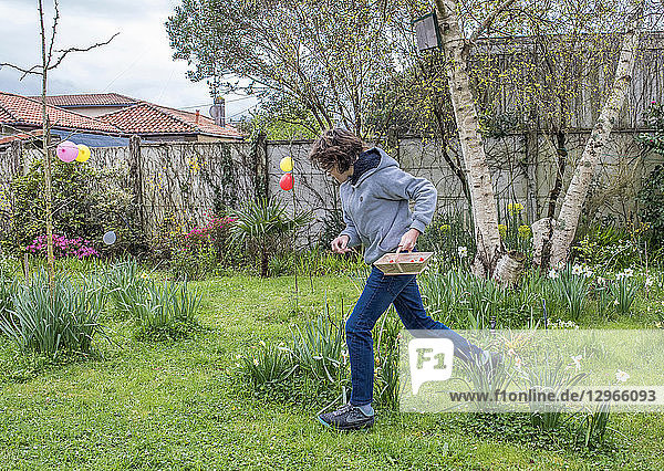 France  Easter  teenager hunting chocolate eggs in a garden.