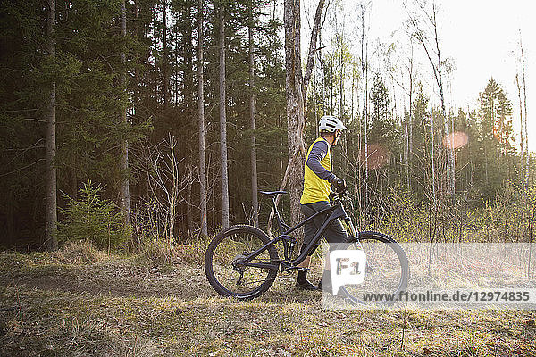 Mid adult man with a mountain bike in a forest