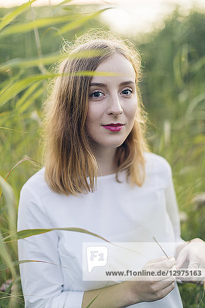 Young woman standing in a field of grass in Karlskrona Sweden