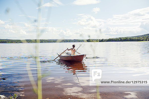 Man rowing a boat on a lake in Dalarna  Sweden