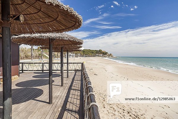 Mediterranean sea  spring sunny day  baech and umbrella terrace bar  Costa Dorada  Catalonia  Spain.