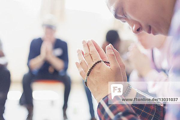 Mann betet mit Gebetsperlen in einer Gebetsgruppe