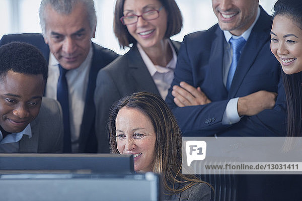 Smiling business people working at computer in office