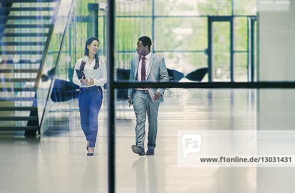 Business people walking and talking in office lobby