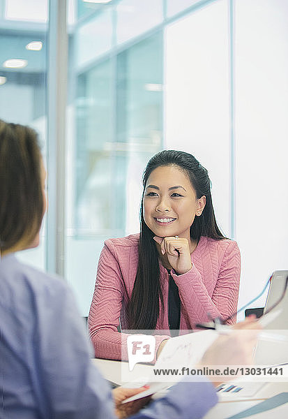 Smiling  attentive businesswoman listening to colleague in meeting