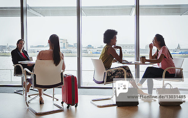 Geschäftsfrauen im Gespräch in der Business-Lounge eines Flughafens