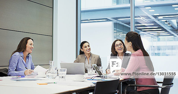 Happy businesswomen talking in conference room meeting