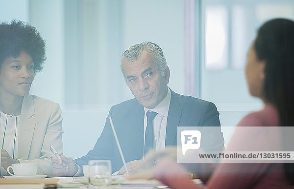 Attentive senior businessman listening in conference room meeting