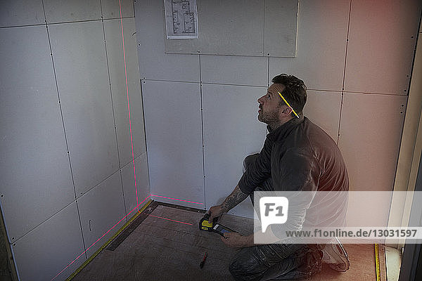 Bauarbeiter mit Lasermessgerät