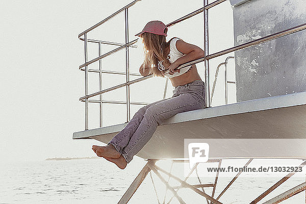 Frau entspannt sich auf dem Rettungsschwimmerturm