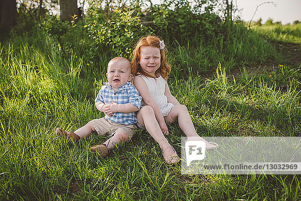 Young children crying on grass