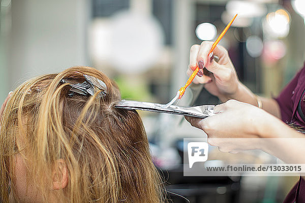 Friseur färbt den Kunden im Salon die Haare