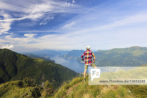 Hiker on Monte Legnoncino admires Lake Como  Lecco province  Lombardy  Italy