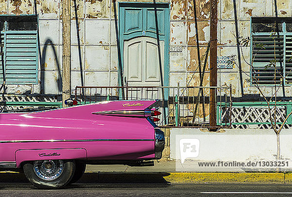 Ein amerikanischer Oldtimer fährt an einem alten Gebäude in Varadero  Kuba  Westindien  Karibik  vorbei